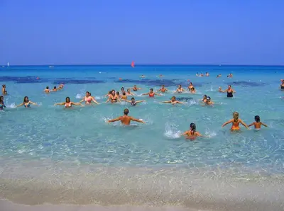 a group of people in the water at the beach at AR Palace Hotel - Palermo in Isola delle Femmine