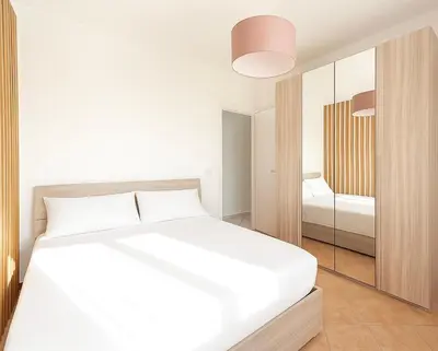 a white bedroom with a bed and a mirror at AR Palace Hotel - Palermo in Isola delle Femmine