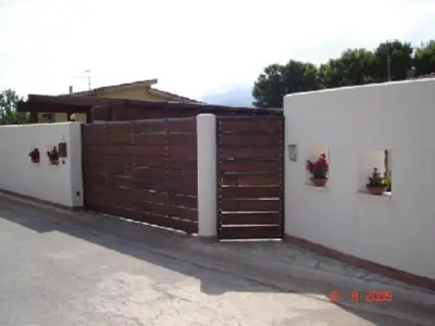 a brown and white fence with a wooden gate at Scopello sul mare 1 in Castellammare del Golfo