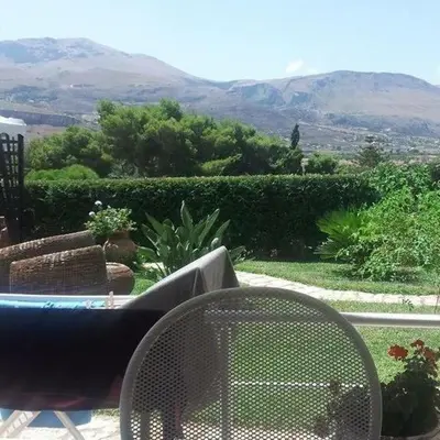a table and a chair with a view of a mountain at Scopello sul mare 1 in Castellammare del Golfo
