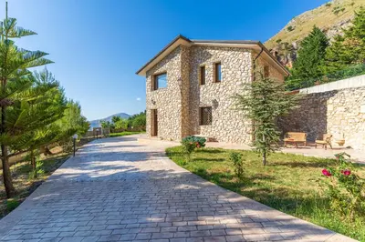 a stone house with a stone driveway at Villa Romitello con Piscina Total Relax in Borgetto