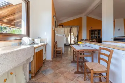 a kitchen with a counter and a table and chairs at Villa Romitello con Piscina Total Relax in Borgetto