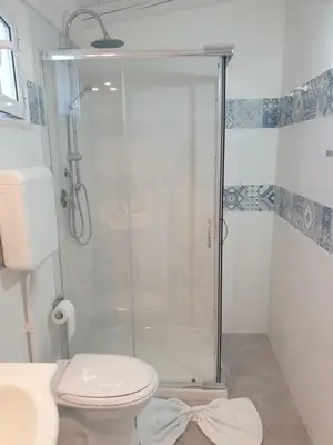 a bathroom with a shower with a toilet and a sink at CASA DEL SOLE in Alcamo