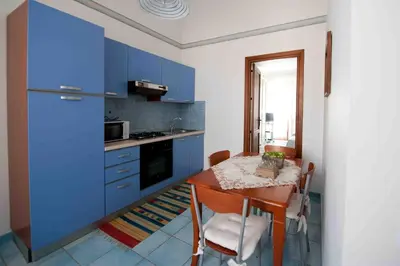 a kitchen with blue cabinets and a table with chairs at Residence Il Capo in Palermo