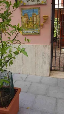a sign on the side of a building with a plant at Residence Il Capo in Palermo