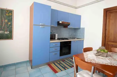 a kitchen with blue cabinets and a table with a tableablish at Residence Il Capo in Palermo