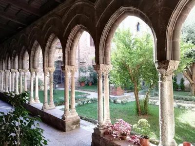 an old building with columns and arches in a garden at Casa Magione in Palermo