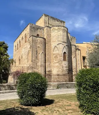 an old brick building with two bushes in front of it at Casa Magione in Palermo
