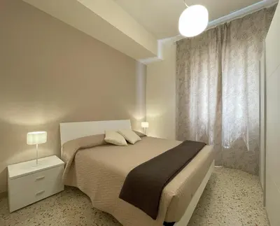 a white bedroom with a bed and a window at Casa Magione in Palermo
