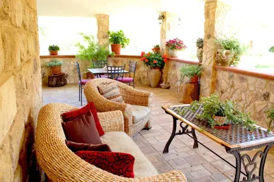 an outdoor patio with wicker chairs and a table at Casale Orioles in Torretta