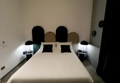 a bedroom with a large white bed with two lamps at Le stanze di Bianca in Palermo