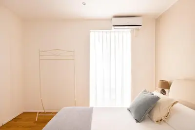 a white bedroom with a bed and a window at Moncada Suites & Apartments in Palermo