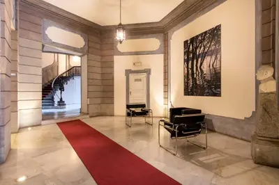 a lobby with two chairs and a red rug at Moncada Suites & Apartments in Palermo