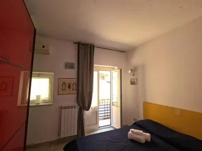 a bedroom with a bed and a door with a window at casa magoo in Palermo