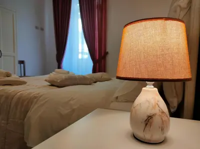 a lamp sitting on a table next to a bed at Ai Giudici in Palermo
