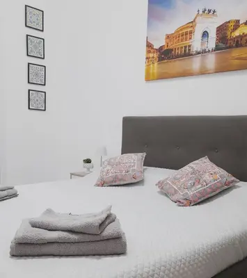 a bed with two pillows and a picture on the wall at Rosina's flat in Palermo