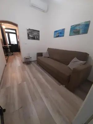 a living room with a couch and a wooden floor at Rosina's flat in Palermo