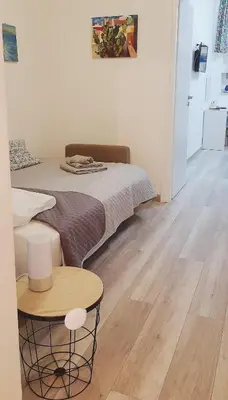 a bedroom with a bed and a table in a room at Rosina's flat in Palermo
