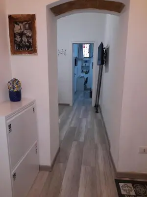 a hallway with white walls and a wooden floor at Rosina's flat in Palermo