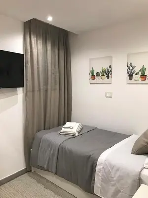 a bedroom with a bed and a tv at La Casetta Paternò “Nel Cuore Pulsante di Palermo” in Palermo