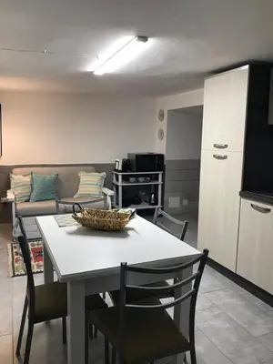 a kitchen and a living room with a table and chairs at La Casetta Paternò “Nel Cuore Pulsante di Palermo” in Palermo