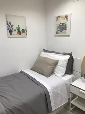 a white bedroom with a bed with two pillows at La Casetta Paternò “Nel Cuore Pulsante di Palermo” in Palermo