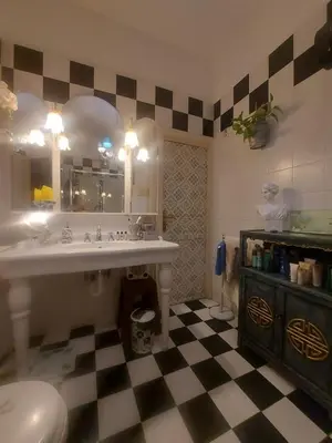 a bathroom with a sink and a checkered floor at LE VELE in Palermo