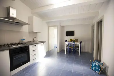a kitchen with a stove and a table in it at Sciabika Edificio Flowers in Castellammare del Golfo