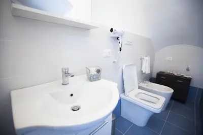a bathroom with a white sink and a toilet at Sciabika Edificio Flowers in Castellammare del Golfo
