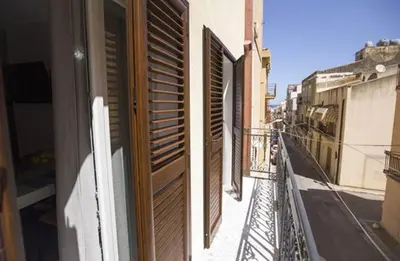 a balcony with wooden shutters on a building at Sciabika Edificio Flowers in Castellammare del Golfo