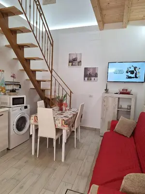 a living room with a dining room table and a staircase at Casa dolce casa in Partinico