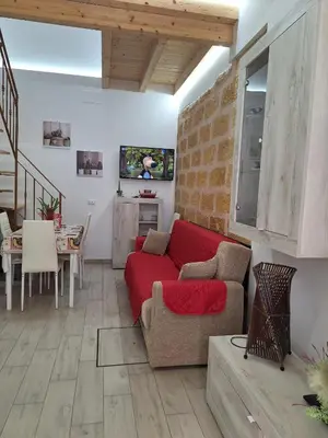 a living room with a red couch and a table at Casa dolce casa in Partinico