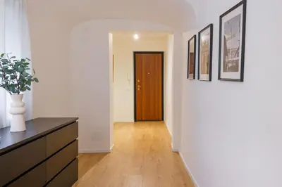 a hallway with white walls and a wooden door at Parlamento Apartment - Esclusivo 120mq centro storico Palermo in Palermo
