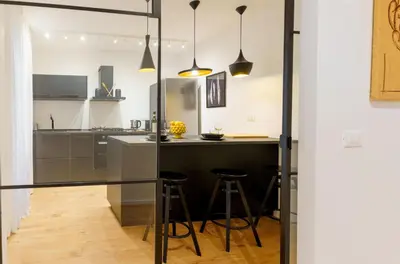 a kitchen with a counter and bar with stools at Parlamento Apartment - Esclusivo 120mq centro storico Palermo in Palermo