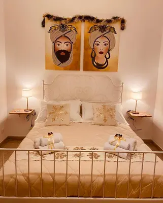 a bedroom with a bed with two paintings on the wall at Palermo Center Residenza IN Cattedrale Superior Apartment in Palermo