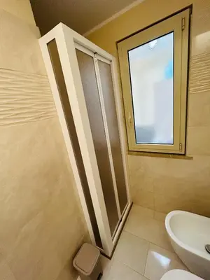 a bathroom with a shower and a sink and a window at SicilyHouse Palermo in Palermo