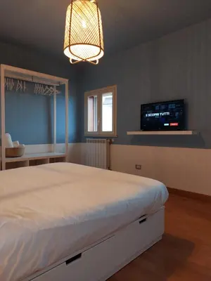 a bedroom with a bed and a tv on the wall at Piazza Mondello Lifestyle Home Palermo in Mondello