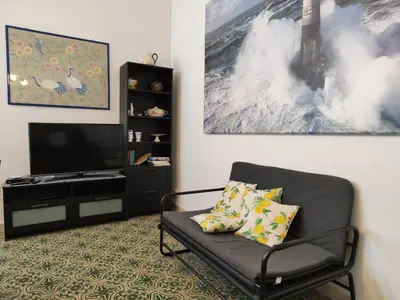 a living room with a couch and a tv at Seafront Apartment in Villa with Swimming Pool and Parking in Alcamo Marina