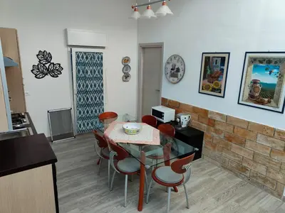 a kitchen and dining room with a table and chairs at Seafront Apartment in Villa with Swimming Pool and Parking in Alcamo Marina