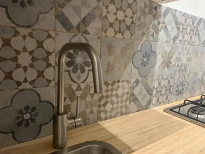 a kitchen sink with a faucet and tiles on the wall at San Saverio Home in Palermo