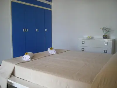 a bedroom with a large bed with blue cabinets at Villa On The Beach Spiaggia Plaia in Castellammare del Golfo