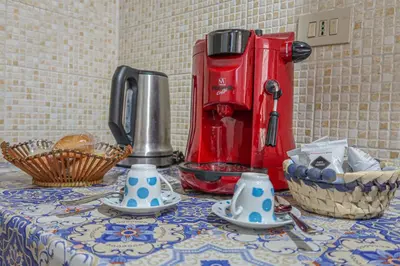 a table with a coffee maker and plates on it at N'Amuri di Casa in Palermo