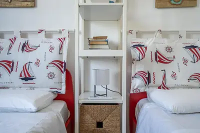 a bedroom with two beds with red and white pillows at VILLA HIBISCUS in Castellammare del Golfo