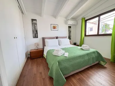 a bedroom with a bed with a green blanket on it at Meetup on The Terrace View With private parking in Palermo