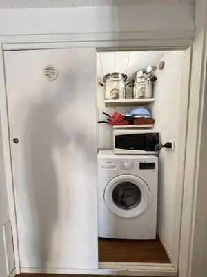 a small kitchen with a washing machine in a room at Meetup on The Terrace View With private parking in Palermo