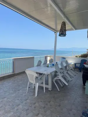 a table and chairs on a patio with the ocean at Villa GLORIA intero alloggio sulla spiaggia 8 posti letto 15 minuti da Palermo e 35 da Cefalu in Casteldaccia