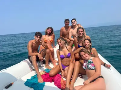 a group of people sitting on a boat in the water at Villa GLORIA intero alloggio sulla spiaggia 8 posti letto 15 minuti da Palermo e 35 da Cefalu in Casteldaccia