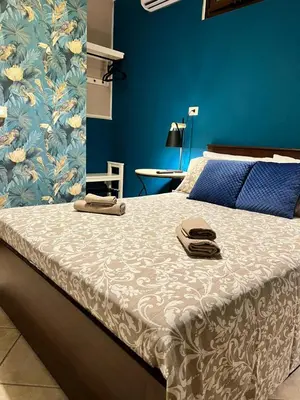 a bed in a bedroom with a blue wall at CASE VANELLA GRANDE aspra Bagheria in Bagheria