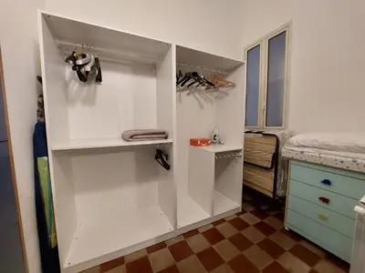 a white closet with shoes on shelves in a room at Olivuzza Apartment in Palermo