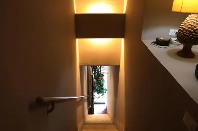 a hallway with a light at the end of a room at Palazzo Cutò suite & charme in Palermo